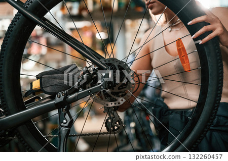 Making it clean. Repair woman in bicycle shop, working in store 132260457