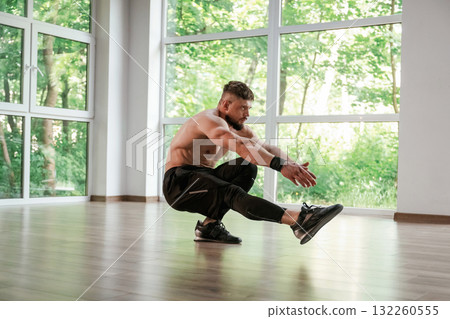 Yoga stretching. Strong muscular man is working out in the gym Yoga stretching. Strong muscular man is working out in the gym 132260555