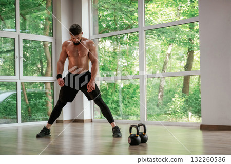 Focused at the exercise. Strong muscular man is working out in the gym Focused at the exercise. Strong muscular man is working out in the gym 132260586