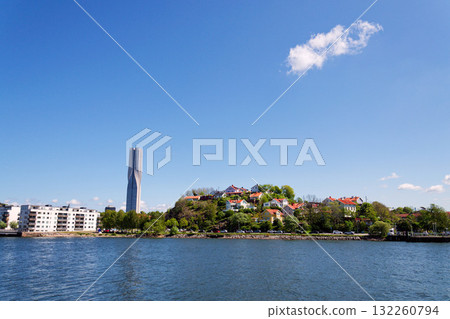 Colony of small wooden historic houses on the Slottsberget mountain with the tallest Scandinavian building Karlatornet skycraper in Lindholmen, Gothenburg, Sweden 132260794