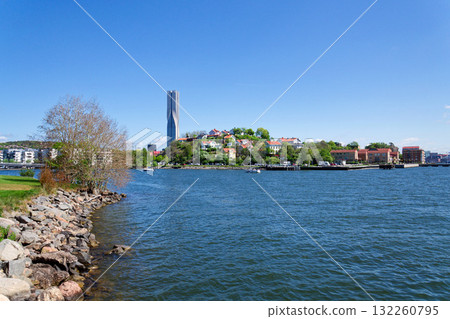 Colony of small wooden historic houses on the Slottsberget mountain with the tallest Scandinavian building Karlatornet skycraper in Lindholmen, Gothenburg, Sweden 132260795