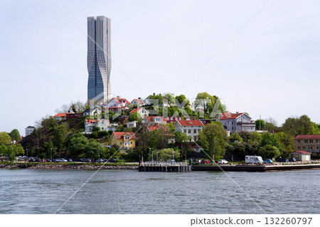 Colony of small wooden historic houses on the Slottsberget mountain with the tallest Scandinavian building Karlatornet skycraper in Lindholmen, Gothenburg, Sweden Colony of small wooden historic houses on the Slottsberget mountain with the tallest Scandinavian building Karlatornet skycraper in Lindholmen, Gothenburg, Sweden 132260797