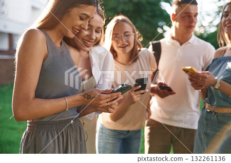 Cheerful, having fun. Group of students are outside together Cheerful, having fun. Group of students are outside together 132261136