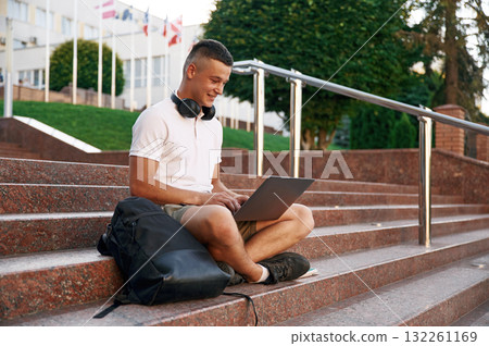 In casual clothes. Young male student is outdoors 132261169