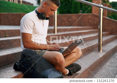 In casual clothes. Young male student is outdoors 132261170