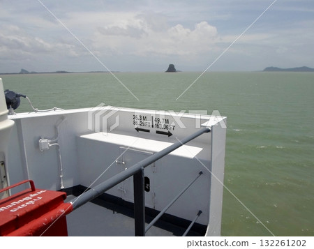 Boat Deck View with Distance Sign and Ocean Horizon Featuring a Distinct Island Boat Deck View with Distance Sign and Ocean Horizon Featuring a Distinct Island 132261202