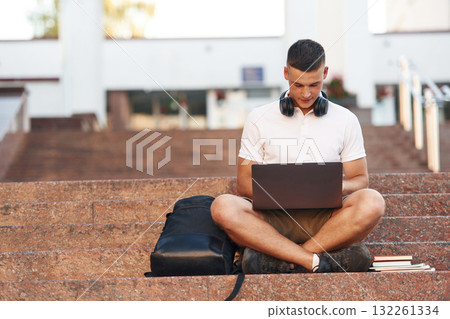 Young male student is outdoors 132261334
