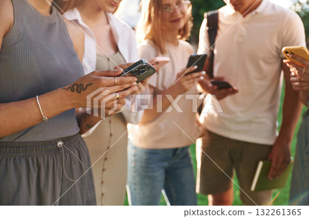 Bunch of smartphones. Group of students are outside together 132261365