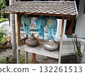 Wooden Shrine Shelf with Blue Lanterns and Metal Pots in a Lush Garden Setting 132261513