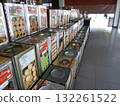 Vibrant Display of Assorted Cookies in Metal Tins at a Market Stall with Tiled Floor 132261522