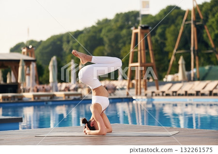 Head stand. Fitness woman is near the pool 132261575