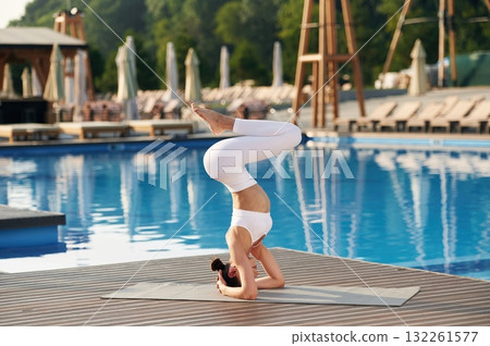Head stand. Fitness woman is near the pool 132261577