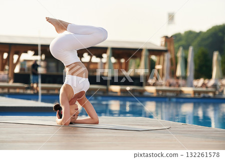 Head stand. Fitness woman is near the pool 132261578