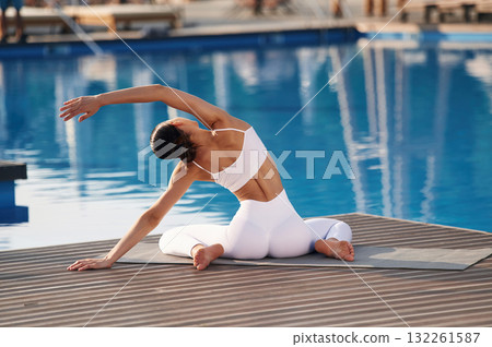Stretching exercises. Fitness woman is near the pool 132261587
