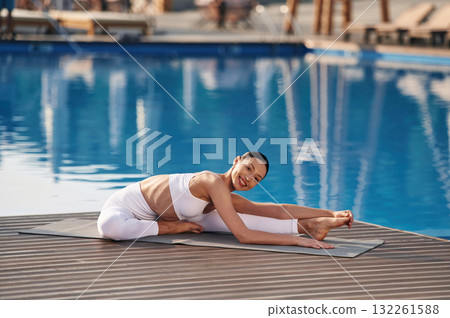 Professional yoga exercises. Fitness woman is near the pool 132261588