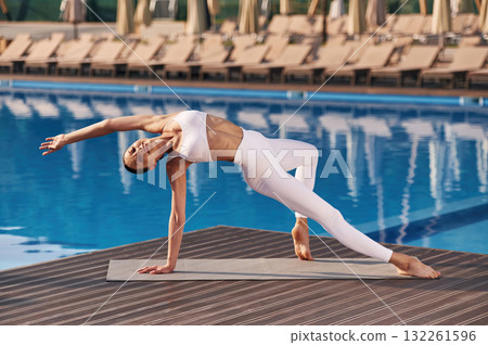 Legs and arms exercise. Fitness woman is near the pool Legs and arms exercise. Fitness woman is near the pool 132261596