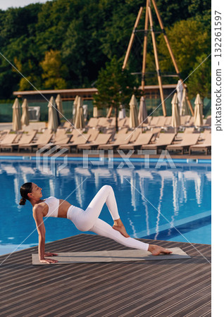 Legs and arms exercise. Fitness woman is near the pool Legs and arms exercise. Fitness woman is near the pool 132261597