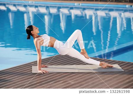 Legs and arms exercise. Fitness woman is near the pool Legs and arms exercise. Fitness woman is near the pool 132261598