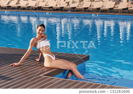 Beautiful woman in bikini is resting by the pool 132261600