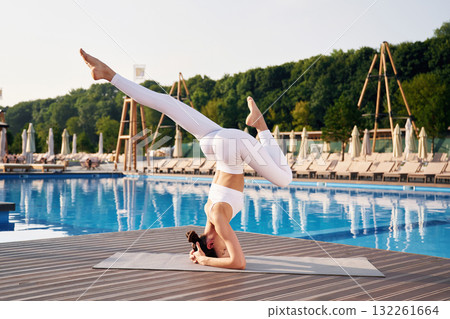 On the head, side, view. Fitness woman is near the pool On the head, side, view. Fitness woman is near the pool 132261664