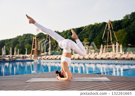 On the head, side, view. Fitness woman is near the pool On the head, side, view. Fitness woman is near the pool 132261665