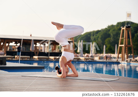 On the head, side, view. Fitness woman is near the pool On the head, side, view. Fitness woman is near the pool 132261676