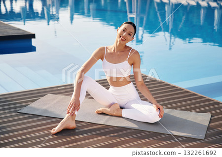 Clear water behind. Fitness woman is near the pool 132261692