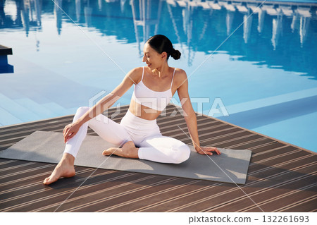Clear water behind. Fitness woman is near the pool 132261693