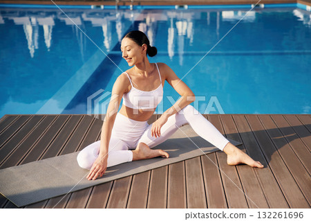 Resting, taking a break. Fitness woman is near the pool Resting, taking a break. Fitness woman is near the pool 132261696