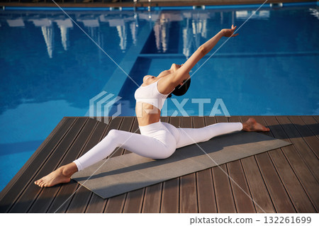 Doing twine. Fitness woman is near the pool Doing twine. Fitness woman is near the pool 132261699