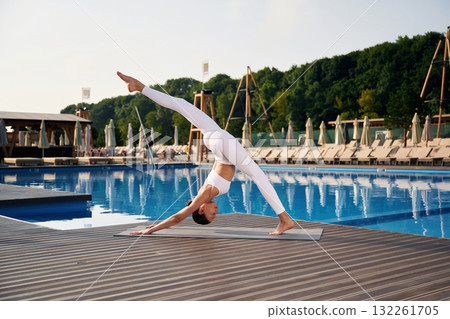 Hobby of yoga, doing exercise. Fitness woman is near the pool Hobby of yoga, doing exercise. Fitness woman is near the pool 132261705