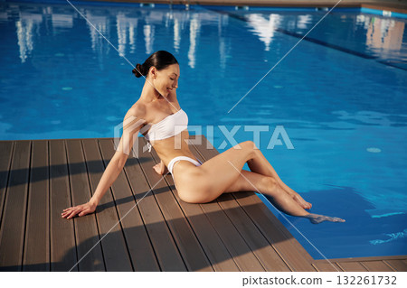 Near the water, rest. Beautiful woman in bikini is resting by the pool 132261732