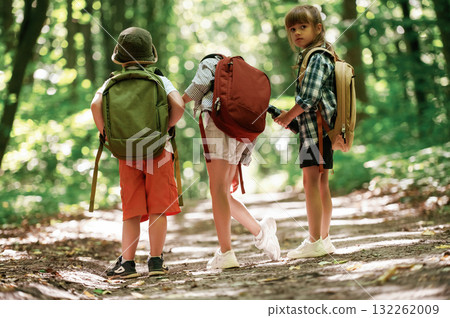 Two girls and a boy. Kids in forest at summer daytime together 132262009