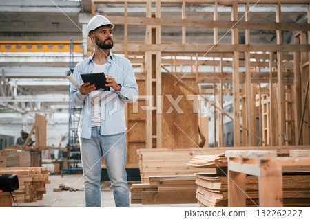 Unfinished project, holding digital tablet. Industrial worker in wooden warehouse Unfinished project, holding digital tablet. Industrial worker in wooden warehouse 132262227