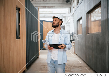 Unfinished project, holding digital tablet. Industrial worker in wooden warehouse Unfinished project, holding digital tablet. Industrial worker in wooden warehouse 132262231