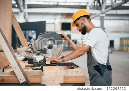 Process of cutting the wood. Industrial worker in warehouse 132262232