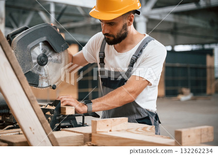 Side view, cutting the wood. Industrial worker in the warehouse 132262234