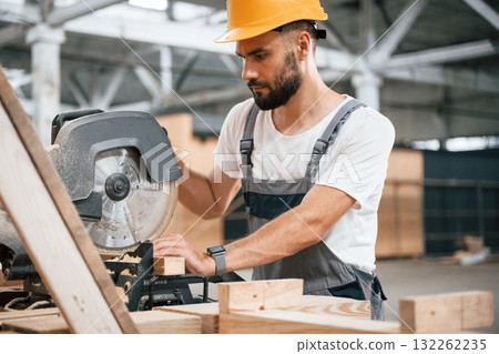 Side view, cutting the wood. Industrial worker in the warehouse 132262235