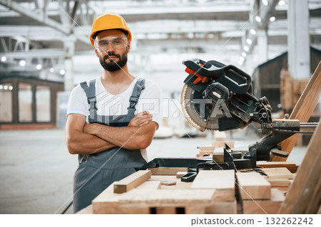 Standing with arms crossed. Industrial worker in wooden warehouse Standing with arms crossed. Industrial worker in wooden warehouse 132262242