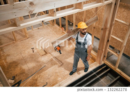 In yellow hardhat. Industrial worker in wooden warehouse In yellow hardhat. Industrial worker in wooden warehouse 132262278