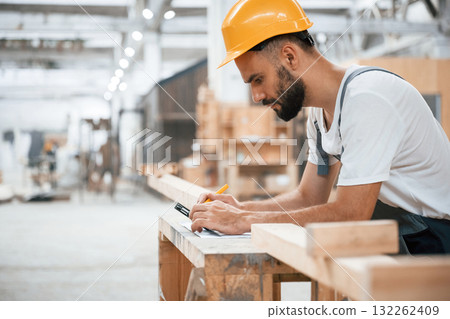 Yellow pen, marks the area. Industrial worker in wooden warehouse Yellow pen, marks the area. Industrial worker in wooden warehouse 132262409