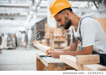 Yellow pen, marks the area. Industrial worker in wooden warehouse Yellow pen, marks the area. Industrial worker in wooden warehouse 132262412