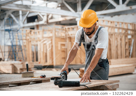 By the table. Industrial worker in wooden warehouse By the table. Industrial worker in wooden warehouse 132262429