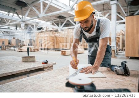 By the table. Industrial worker in wooden warehouse 132262435
