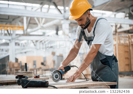 By the table. Industrial worker in wooden warehouse 132262436