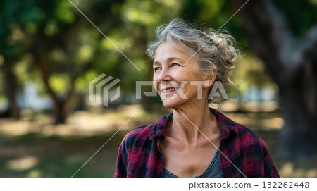 Photorealistic image of an elderly woman, smiling and walking outdoors in a park, natural background, generative ai illustration. 132262448