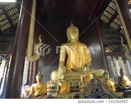Serene Golden Buddha Statues in a Traditional Wooden Temple Interior 132262687