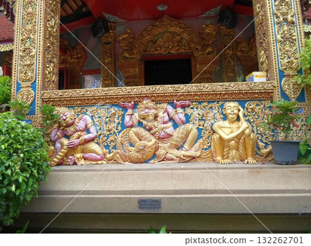 Colorful Temple Wall Relief with Mythical Figures in Gold and Blue Tones 132262701