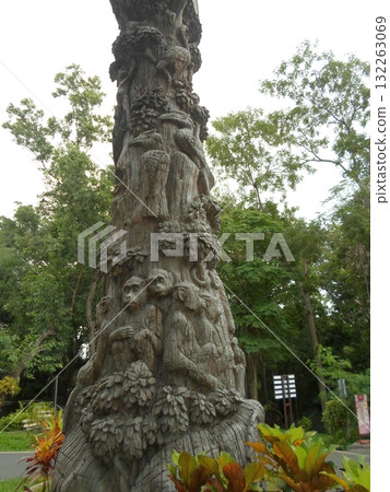 Intricate Carved Tree Sculpture with Animals in a Zoo Surrounded by Plants 132263069
