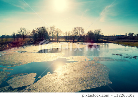 Aerial view of the countryside and frozen creek with a dam in the evening under sunset light. Beautiful natural landscape Aerial view of the countryside and frozen creek with a dam in the evening under sunset light. Beautiful natural landscape 132263102